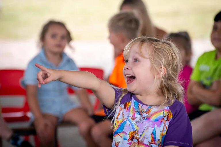 Little girl laughing and pointing at a show